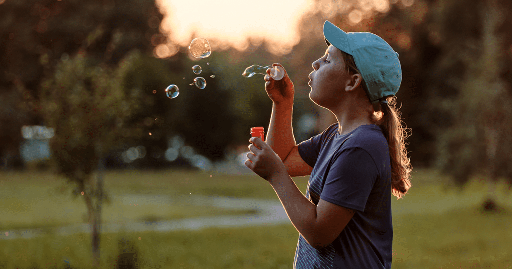 ASD is misunderstood. Girl blowing bubbles.